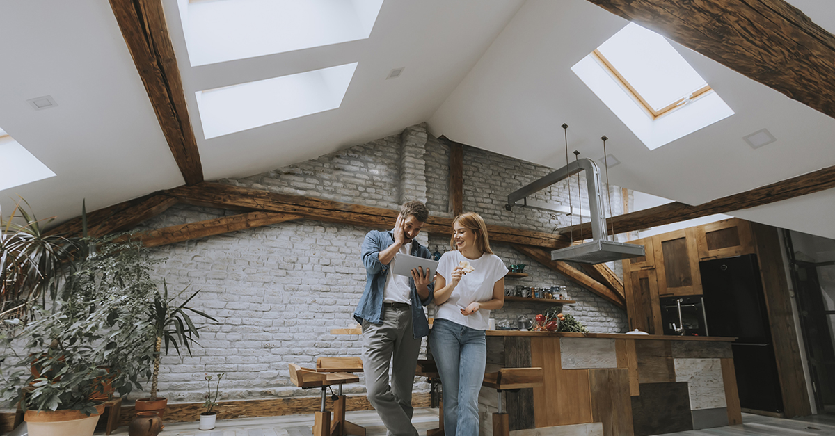 A couple standing in their upstairs apartment