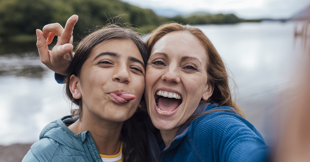 A mom and daughter take a selfie on vacation